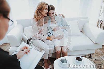 Mother with Pregnant Daughter in Doctor Office. Stock Photo