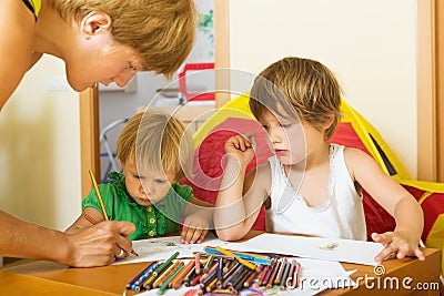 Mother and preschool children playing with pencils Stock Photo