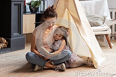 Mother and preschooler daughter hugging read fairytale Stock Photo