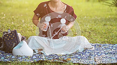 Mother pumping breastmilk in park at sunset Stock Photo