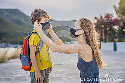 Mother puts her child a face protective mask on the street. Stop the infection. Coronavirus quarantine. Apocalypse Stock Photo