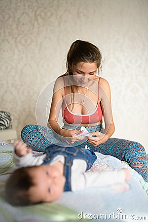 A mother puts on socks on her baby. beautiful mother putting her cute baby socks on. insulates the legs of his child with socks Stock Photo