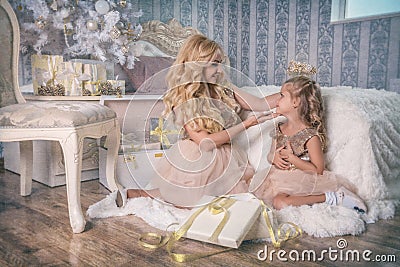 Mother puts a tiara on her daughter`s head in the Christmas Stock Photo