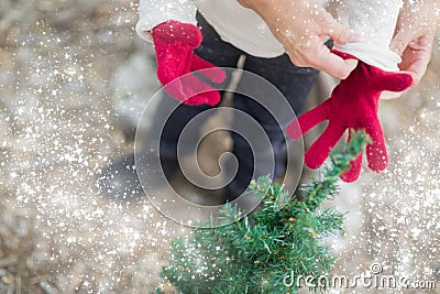 Mother Putting Red Mittens On Child with Snow Effect Stock Photo