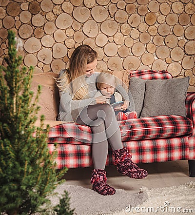 Mother reading a book with baby daughter before Christmas Stock Photo