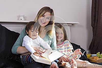 Mother reading to kids in bed Stock Photo