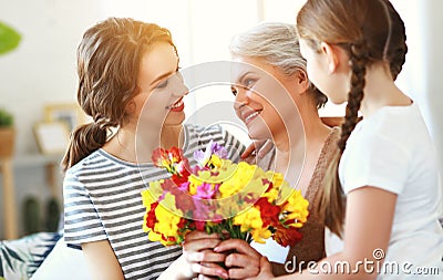Mother`s day! three generations of family mother, grandmother and daughter congratulate on the holiday, give flowers Stock Photo