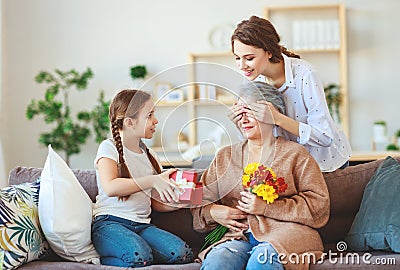 Mother`s day! three generations of family mother, grandmother and daughter congratulate on the holiday, give flowers Stock Photo