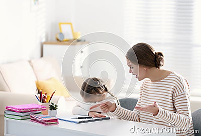 Mother scolding her daughter while helping with homework Stock Photo