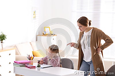 Mother scolding her daughter while helping with homework Stock Photo