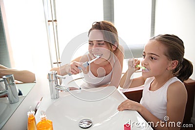 Mother showing her daughter how to brush teeth Stock Photo