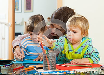 Mother and siblings playing with pencils Stock Photo