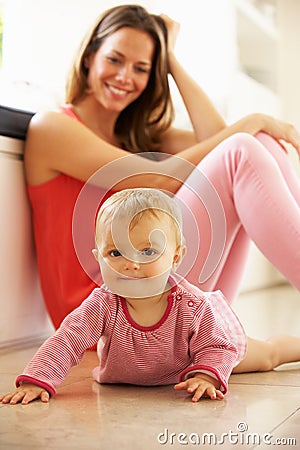 Mother Sitting With Baby Daughter At Home Stock Photo