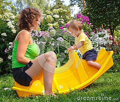 Mother sitting with her son on baby swing Stock Photo