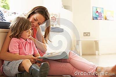 Mother Sitting With Son Reading Story Indoors Stock Photo