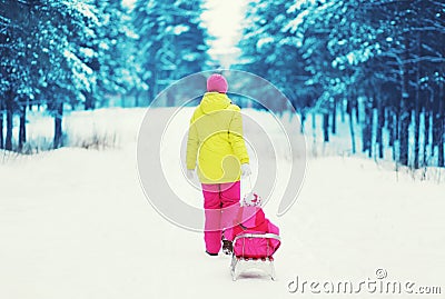 Mother sledding child in the winter Stock Photo