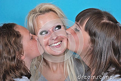 Mother smiles as she receives a kiss on the cheek from her you Stock Photo