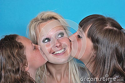 A mother smiles as she receives a kiss on the cheek from her you Stock Photo
