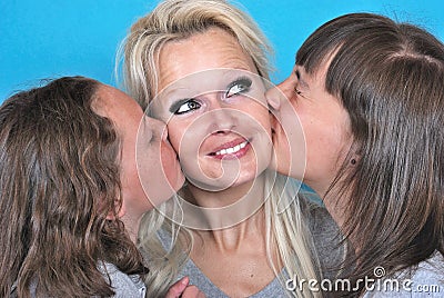 A mother smiles as she receives a kiss on the cheek Stock Photo