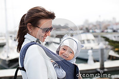 Mother and a smiling cute baby boy in a baby carrier Stock Photo