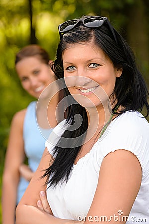 Mother smiling with teen daughter in background Stock Photo
