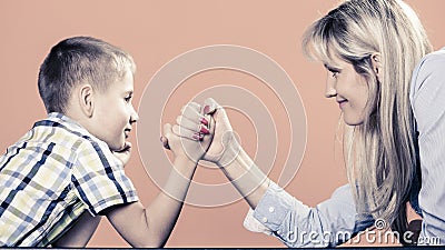 Mother and son arm wrestling. Stock Photo