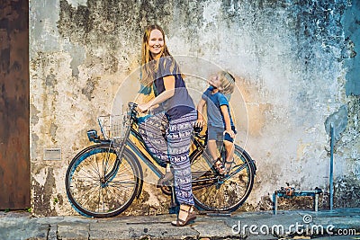 Mother and son on a bicycle. Public street bicycle in Georgetown, Penang, Malaysia Stock Photo