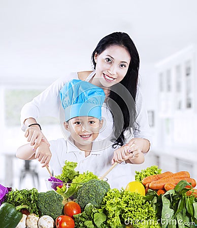 Mother and son cooking vegetable salad Stock Photo