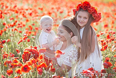 Mother, son and daughter in a field of red poppies Stock Photo