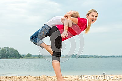 Mother and son doing morning exercises on the beach. Stock Photo