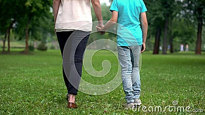 Mother and son holding hands, walking away together, concept of child adoption Stock Photo