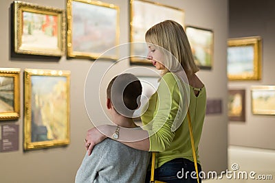 Mother and son looking at paintings in halls of museum Stock Photo