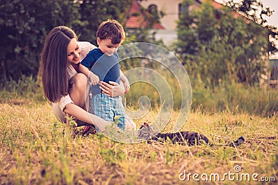 Mother and son playing with cat Stock Photo