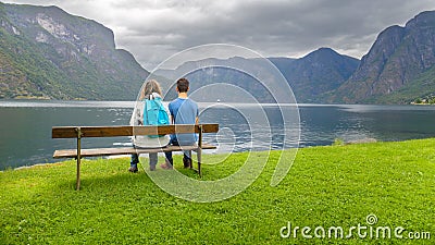 Mother and son sitting on a bench looking at the fjord Stock Photo