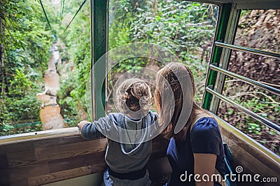 Mother and son in ski lift cabin in summer Over the waterfall. Passengers on a cable car Stock Photo