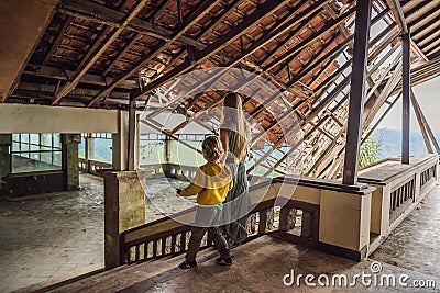 Mother and son tourists in abandoned and mysterious hotel in Bedugul. Indonesia, Bali Island. Bali Travel Concept Stock Photo
