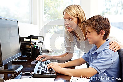 Mother and son using computer at home Stock Photo