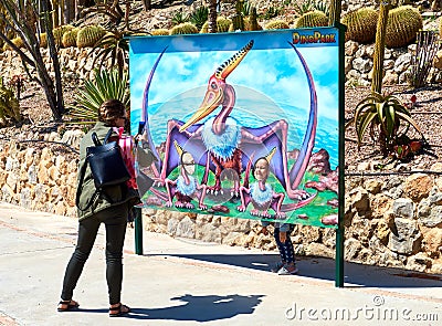Mother taking a funny photo of a daughter in the Dino Park of Al Editorial Stock Photo