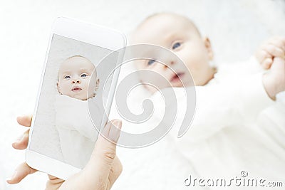 Mother Taking Picture Of Baby Girl On Mobile Phone Stock Photo