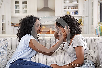 Mother Talking With Unhappy Teenage Daughter On Sofa Stock Photo