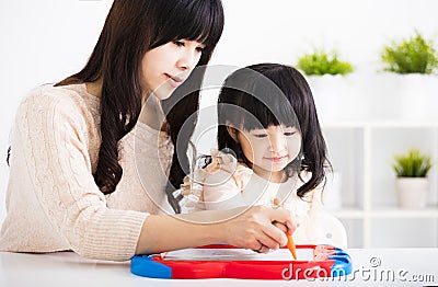 Mother or teacher helping child daughter to writing Stock Photo