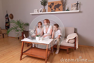 Mother teaches children at home. homeschooling. the teacher is engaged with schoolchildren at home. mom shows children a task in a Stock Photo