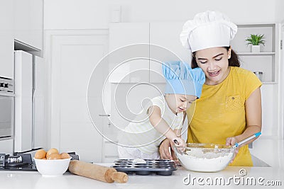 Mother teaches her child making cookie Stock Photo