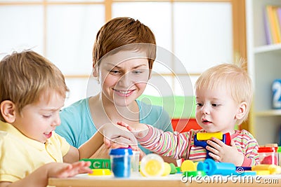 Mother teaches her children to work with colorful play clay toys Stock Photo