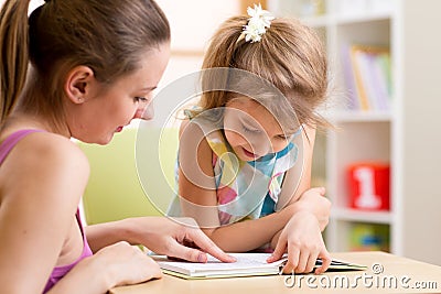 Mother teaching child daughter to read Stock Photo