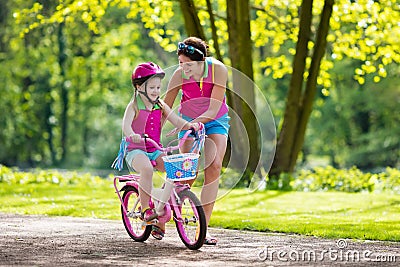 Mother teaching child to ride a bike Stock Photo
