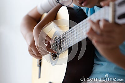 Mother teaching the daughter learning how to play acoustic classic guitar for jazz and easy listening song select focus shallow Stock Photo