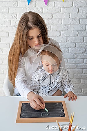 Mother and her little son learning to draw on a chalkboard Stock Photo