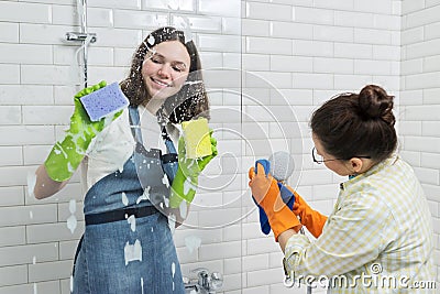 Mother and teenager daughter cleaning together in bathroom Stock Photo