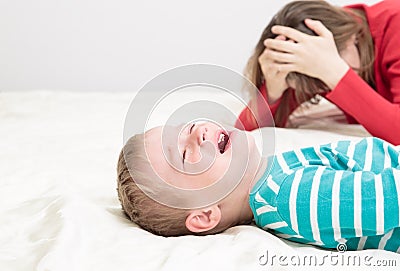 Mother is tired, child is crying Stock Photo